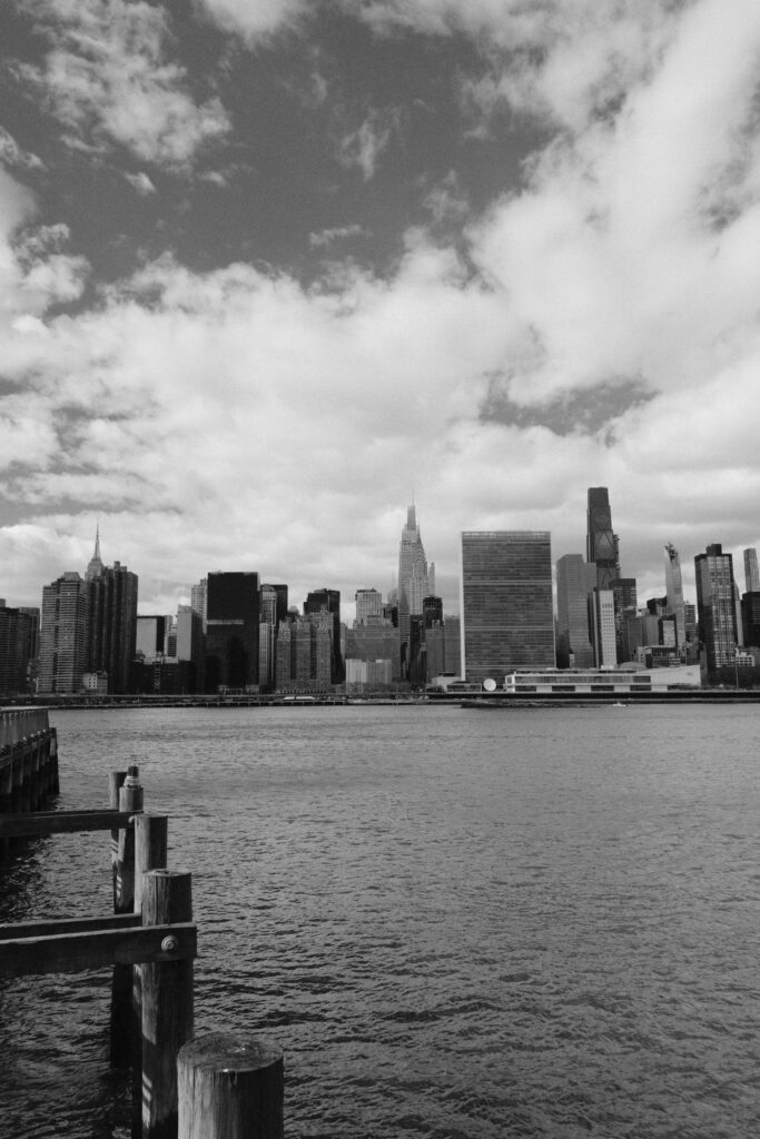 Dramatic black and white view of New York City's skyline from across the water.